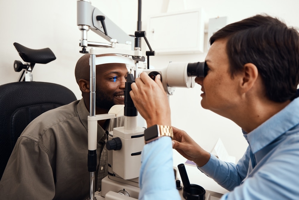 Médico que utiliza un dispositivo especial para examinar el interior del ojo de un paciente.