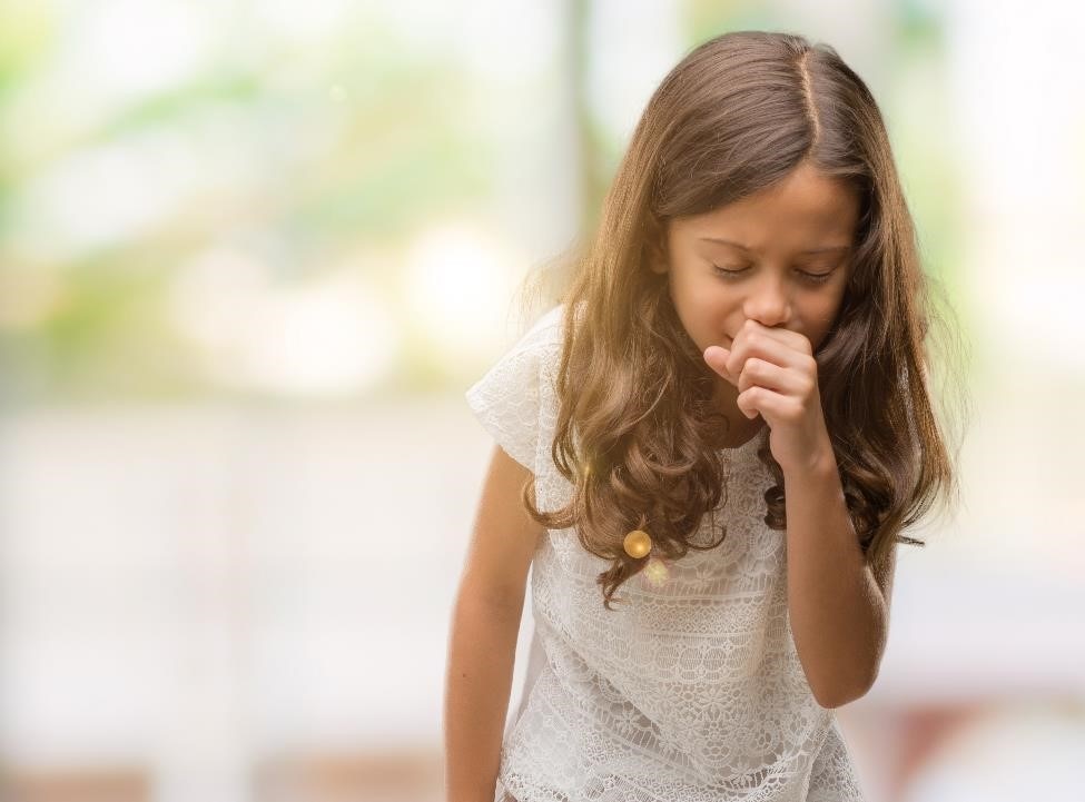 Una niña tosiendo.