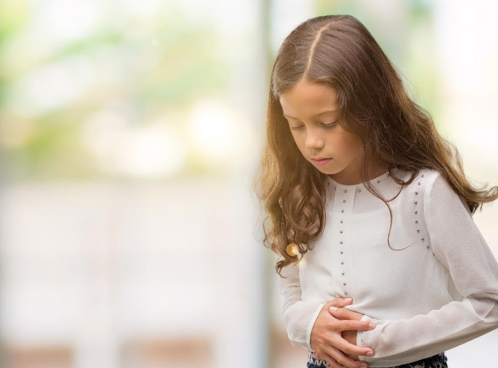 Young girl holding her stomach in pain