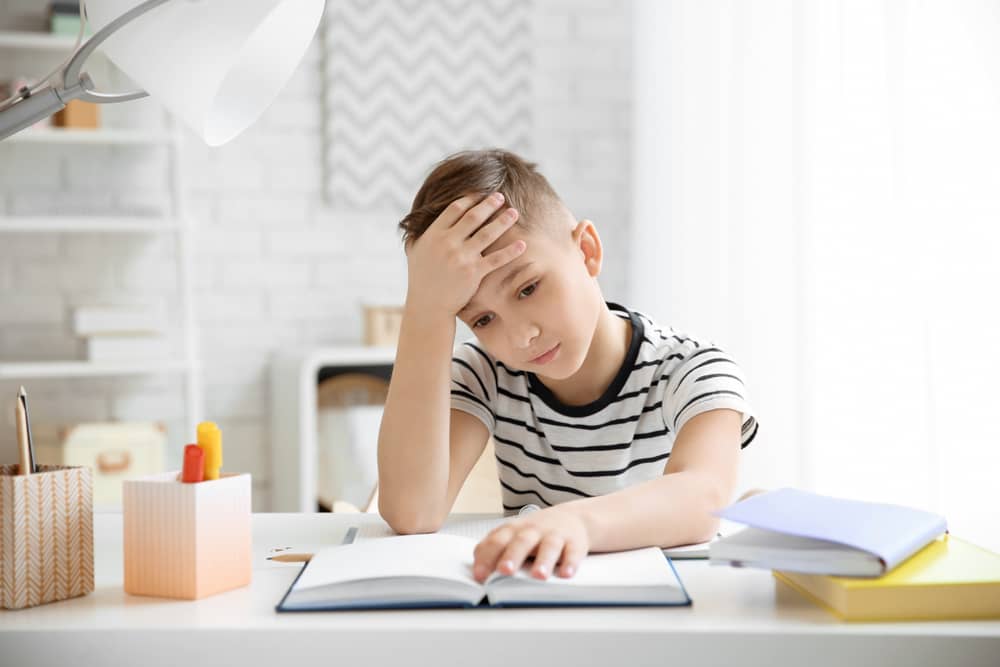 A young boy trying to read.