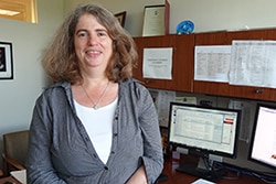 Photo of Dr. Rebekah Rasooly standing at her desk