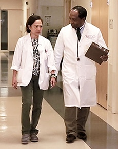 Photo of Dr. Griffen P. Rodgers in medical discussion with staff member