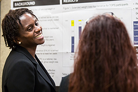 Attendees of the 2016 meeting of the Network of Minority Health Research Investigators talk at a poster session.
