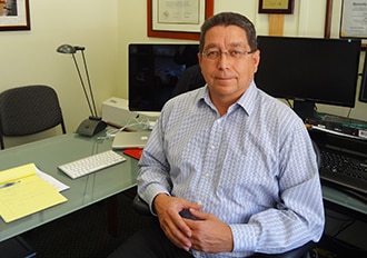 Photo of Dr. Chuck Niebylski sitting at his desk