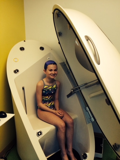 Photo of young girl sitting in a body composition machine