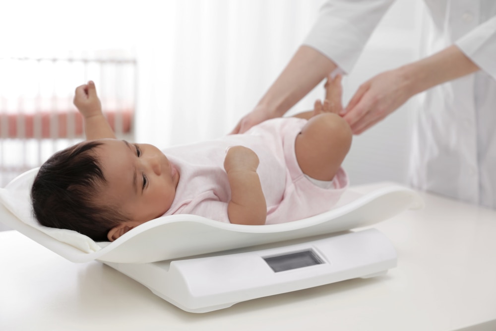 Doctor weighing a baby on a scale