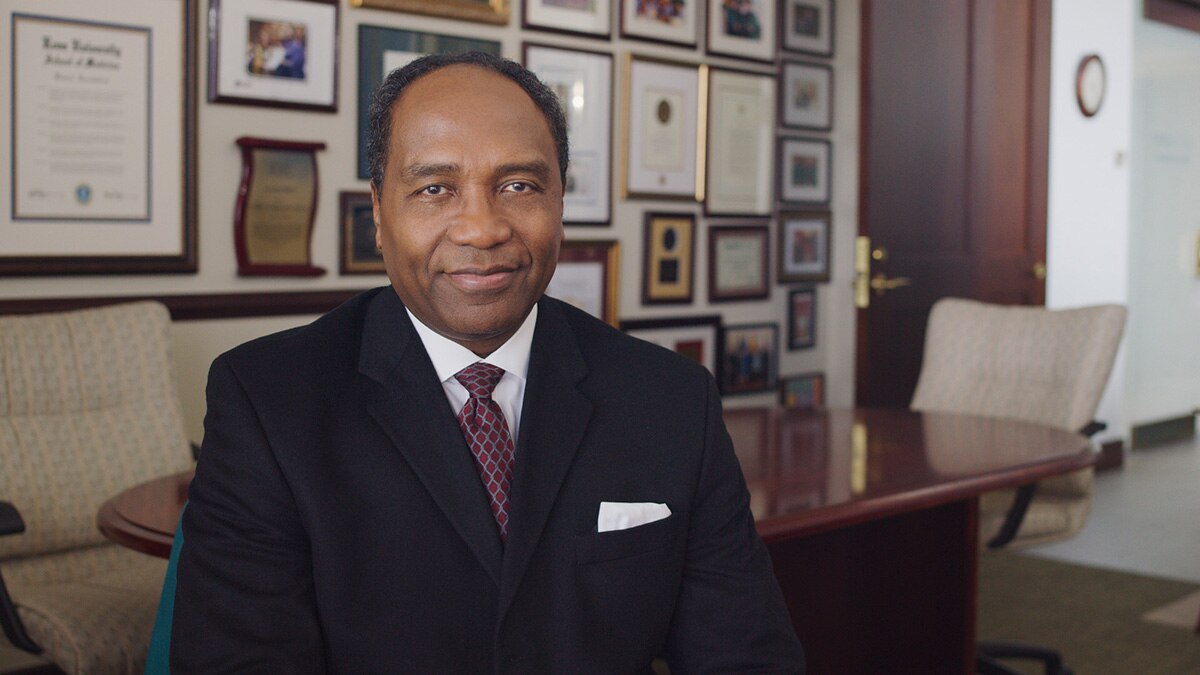 Dr. Griffin P. Rodgers sitting in front of a table and smiling