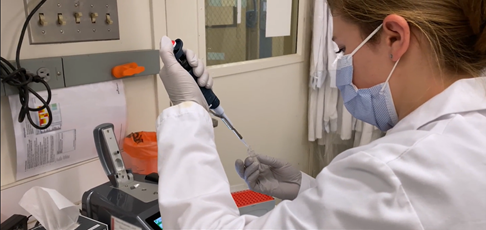 Female scientist using green equipment in a lab.