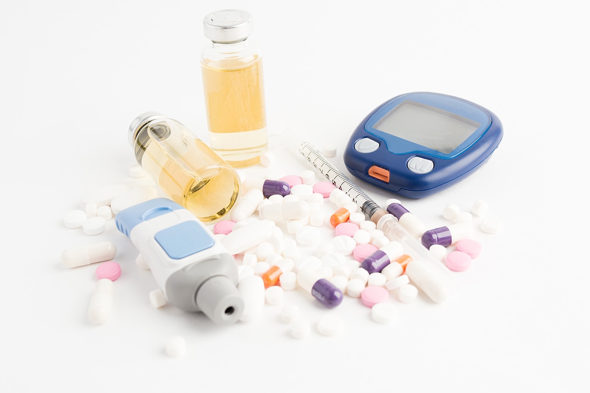 Diabetes blood testing supplies, pills, insulin, and a syringe