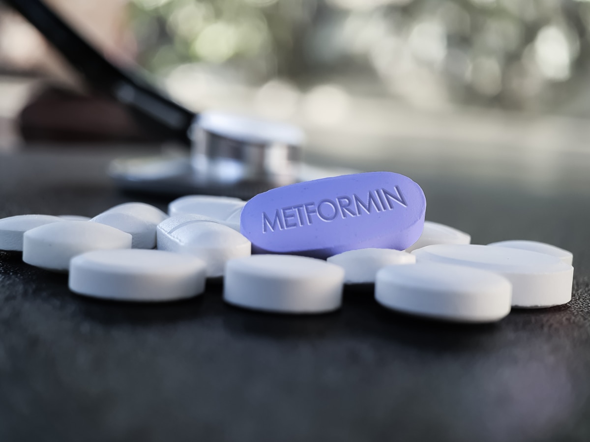 Blue metformin pill on table with stethoscope