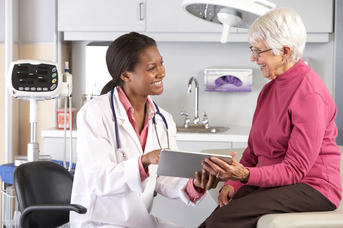 A doctor talking to an older female patient.