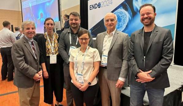 A group of people stand in front of a banner that reads: ENDO 2024.