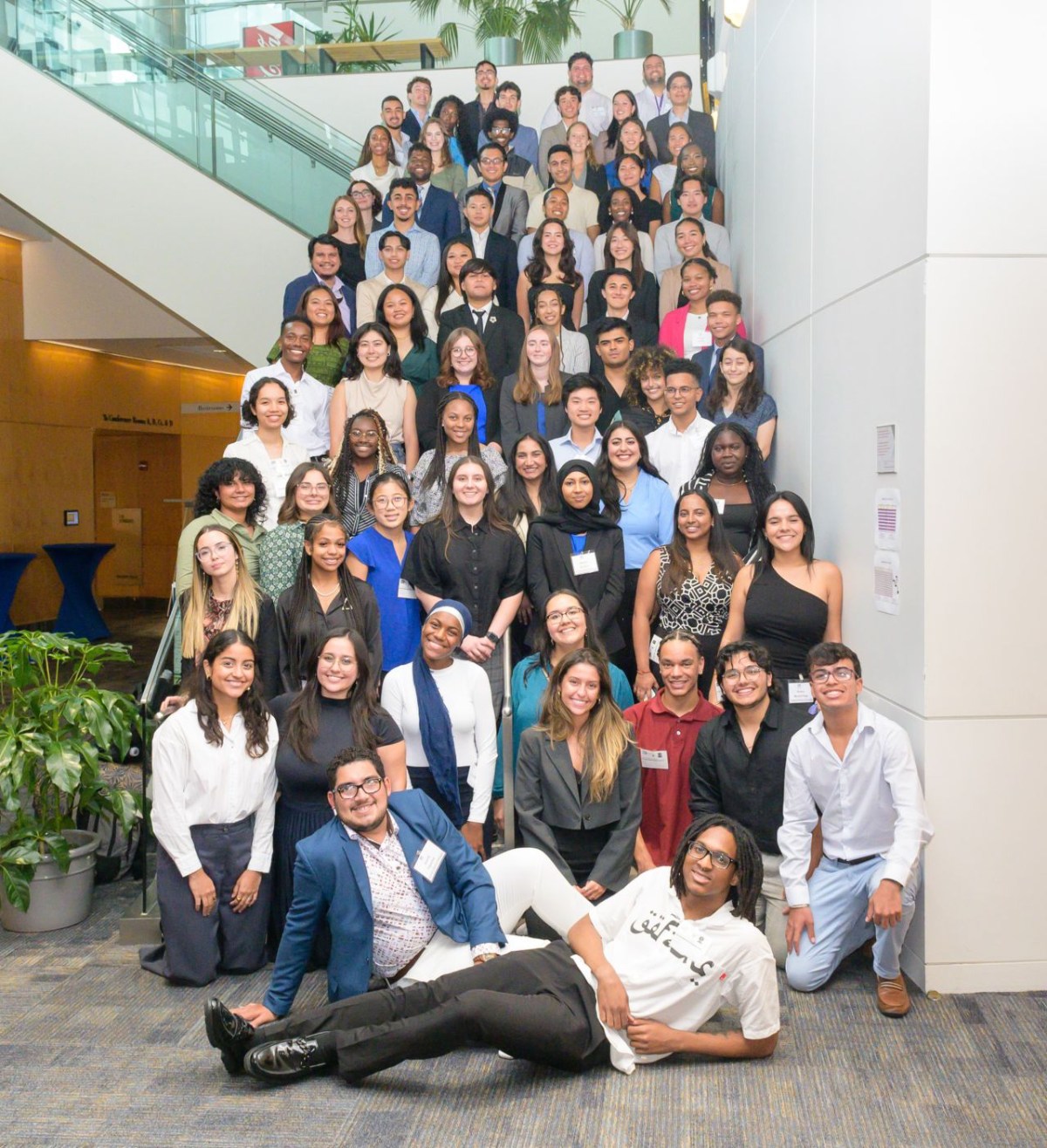 A group of young students on a staircase in the NIH Natcher Center.