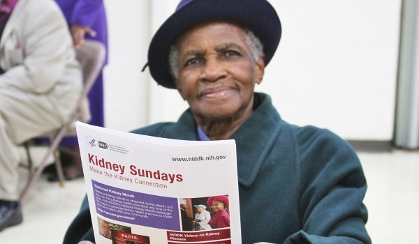 An elderly woman reading a health information book.