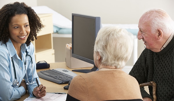 A doctor talking to a patient and their spouse.