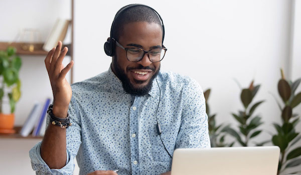 Man wearing headphones and looking at his laptop