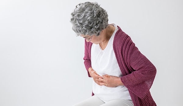 Woman holding stomach in pain.