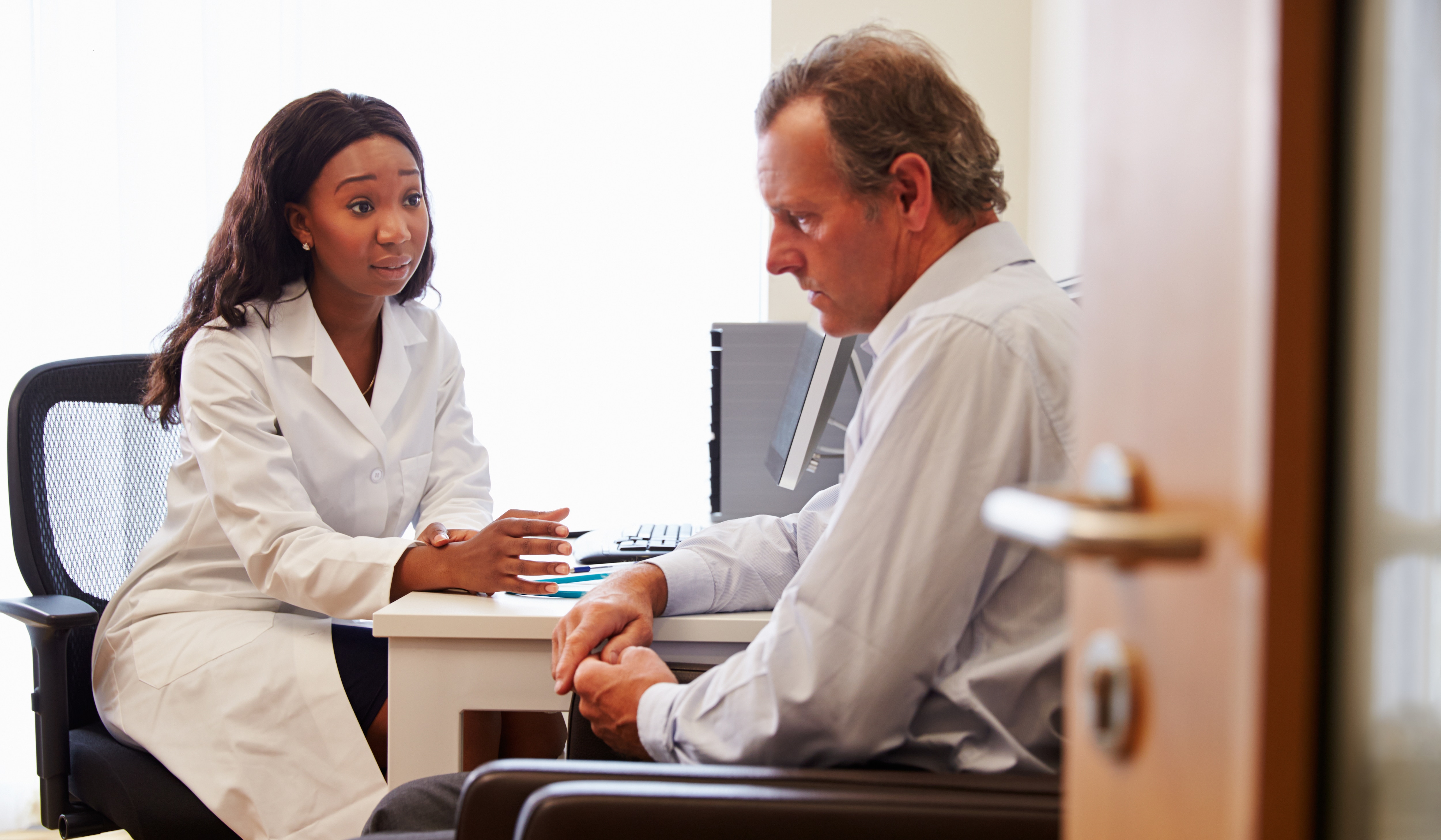 Female Doctor Treating Male Patient Suffering With Depression