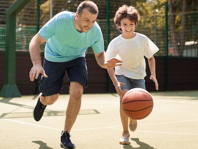 A father and son playing basketball.