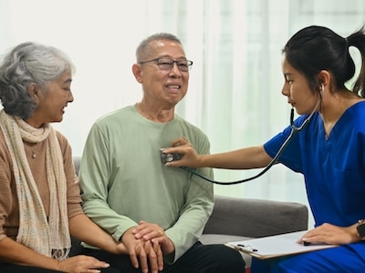 A doctor uses a stethoscope to listen to a senior patient's heartbeat.