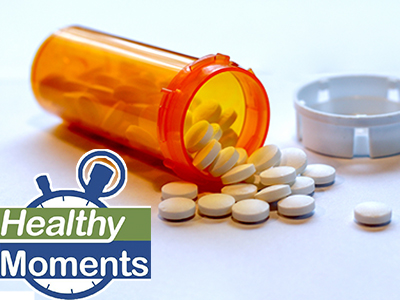 Pill bottle on its side with pills spilling out of it