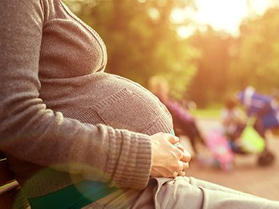 Pregnant woman sitting on a bench.