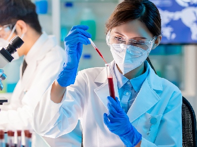 A scientist with a test tube and transfer pipette.