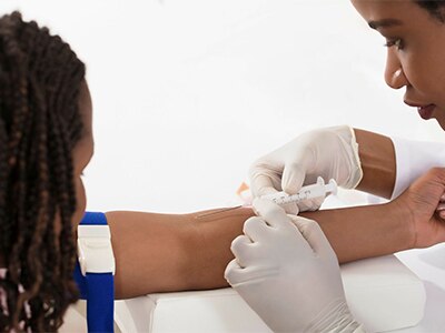 Health professional performing a blood test on another person.