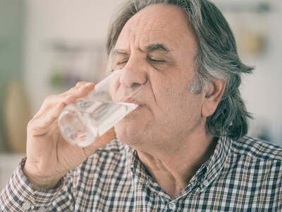 A  man drinking water from a glass.