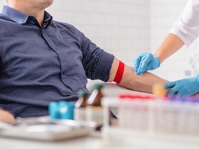 A nurse preparing a patient's arm to draw blood.