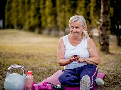 A woman checking her blood glucose levels before physical activity.
