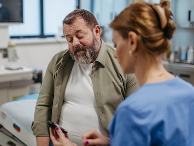 A doctor checking the blood glucose levels of a patient.