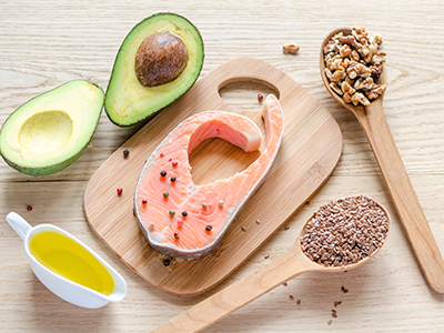A display of avocado, melon, nuts, seeds, and olive oil.
