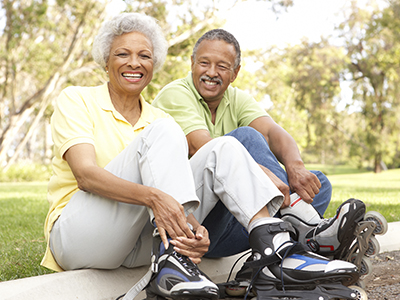 Man and woman putting on inline skates outdoors