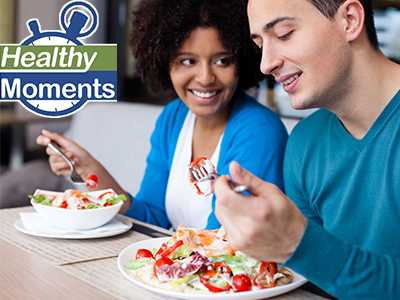 Two teenagers eating salads together