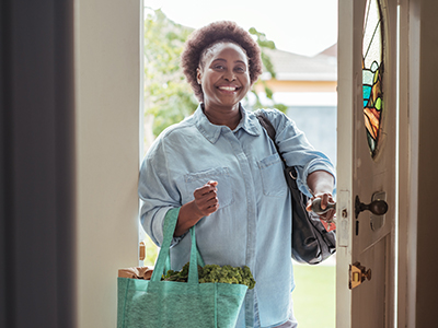 A woman coming home from grocery shopping.