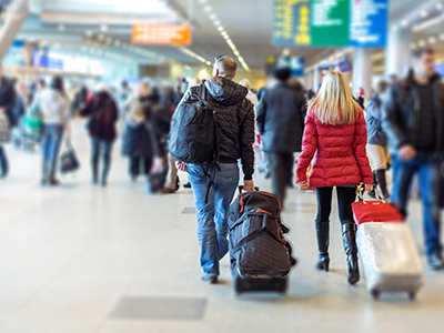 Man and woman rolling luggage through an airport