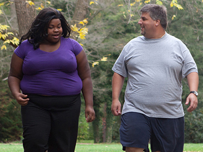 A woman and a man walking outdoors.