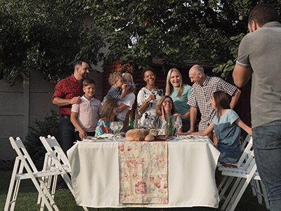 Group of people standing around a table in a backyard