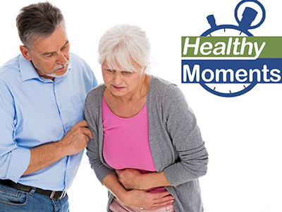 Woman grimacing with her arms wrapped around her torso