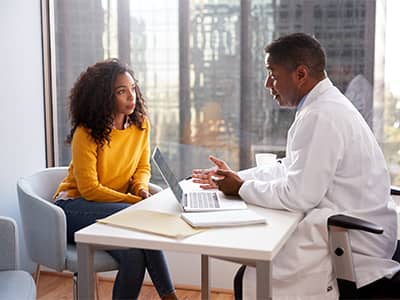 A patient having a consultation with a doctor in a hospital office.