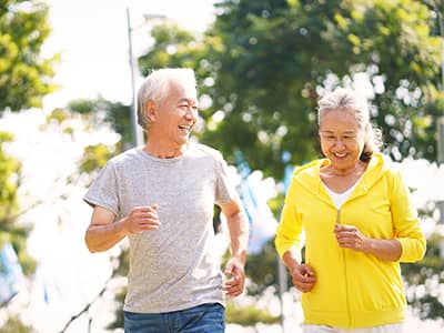 A senior couple running outside.
