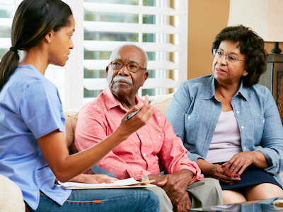 Nurse at a home visit with an older couple.