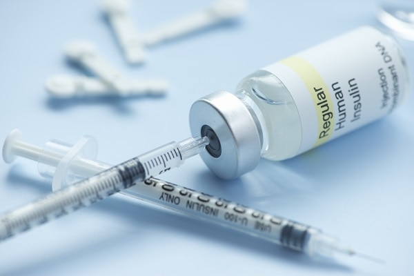 Two syringes and a vial containing insulin.