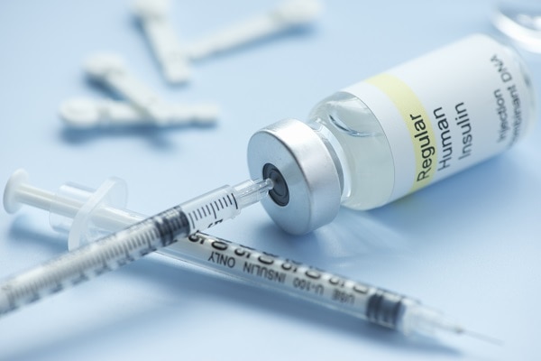 Photo of an insulin vial and a syringe.