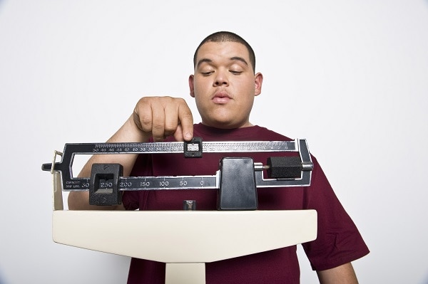 Foto de un hombre joven que se pesa