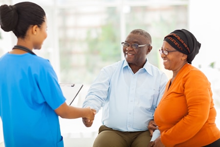 A health care professional talks to a man and a woman about his lab tests.