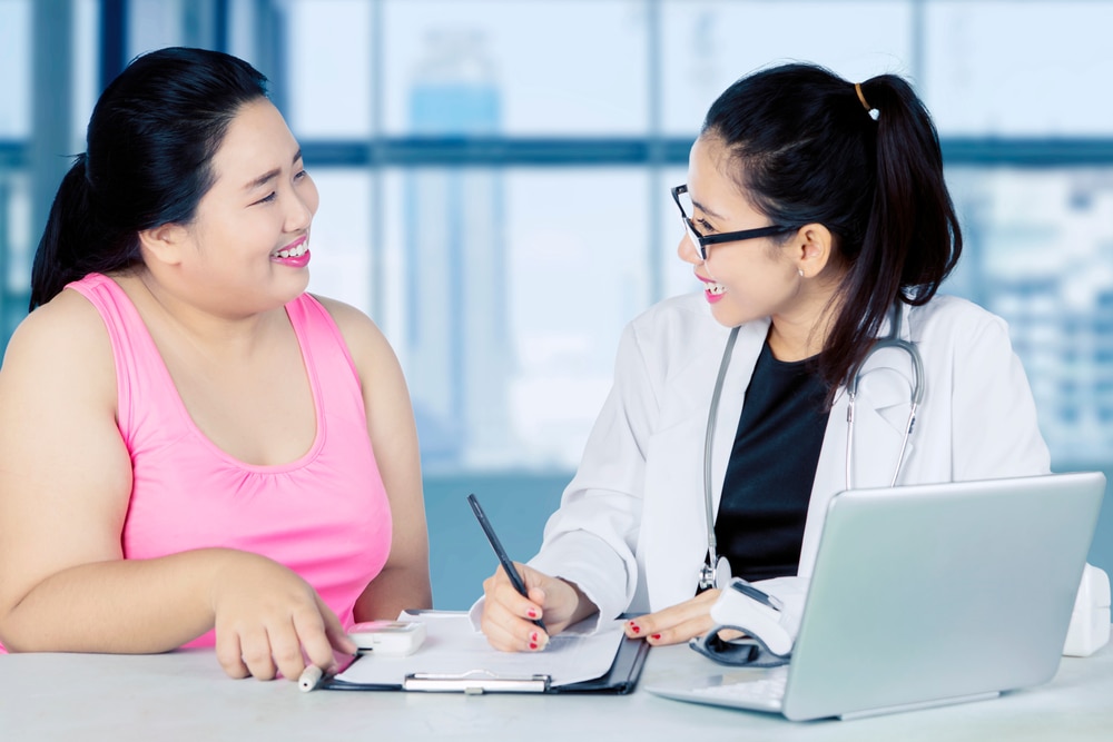 Woman with obesity talking with her doctor.