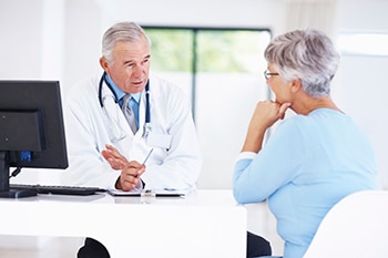 سيدة في منتصف العمر تجري محادثة مع طبيبها في عيادة الطبيب.