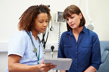 A health care professional speaks to a woman about her medical history